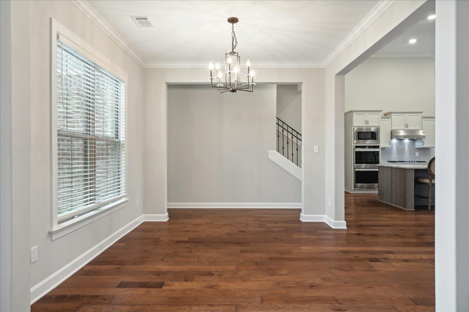6437 Rutherford Circle Arlington, TN 38002 - Photo 12 of 40 Unfurnished dining area featuring dark hardwood / wood-style floors, a chandelier, and ornamental molding