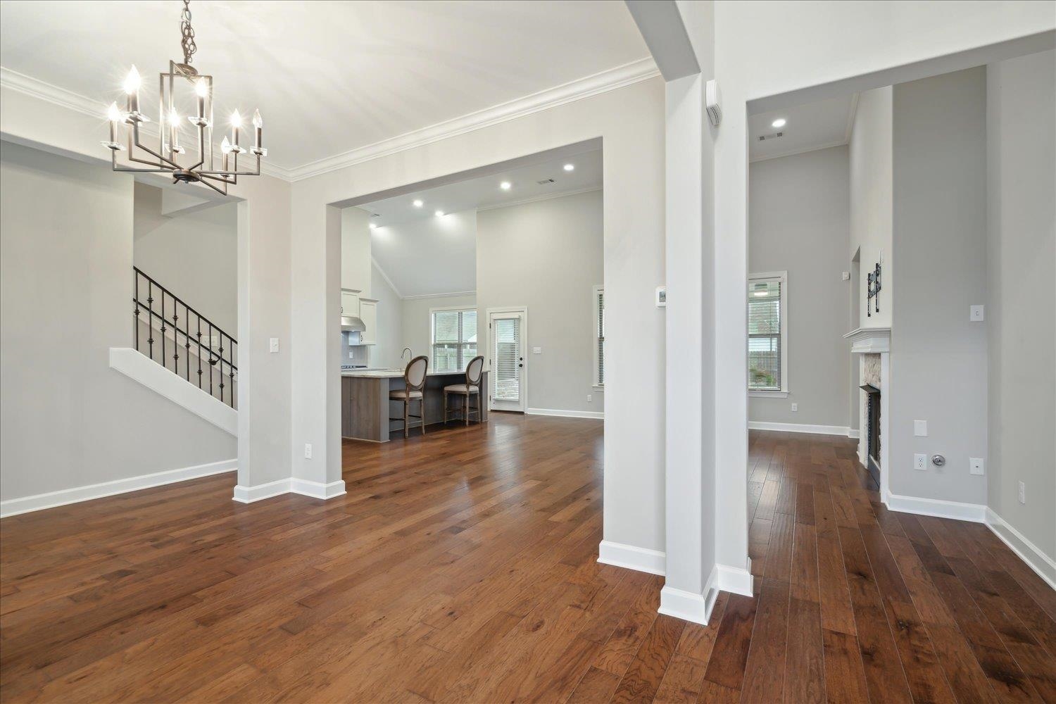6437 Rutherford Circle Arlington, TN 38002 - Photo 13 of 40 Interior space featuring a chandelier, vaulted ceiling, dark hardwood / wood-style flooring, and ornamental molding