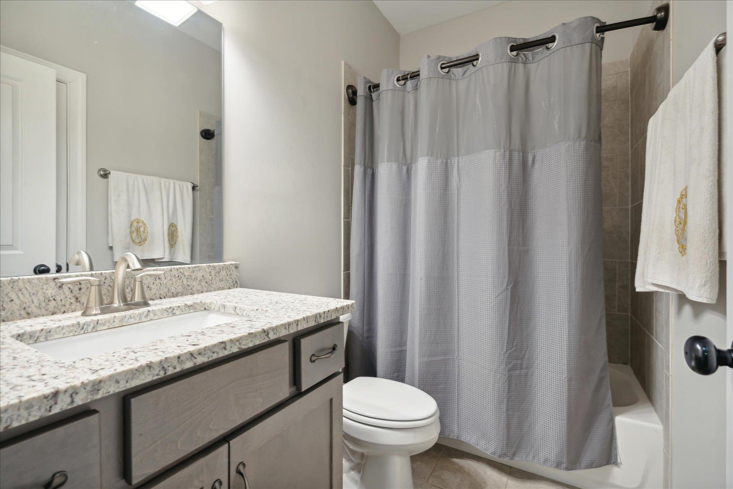 6437 Rutherford Circle Arlington, TN 38002 - Photo 27 of 40 Full bathroom featuring vanity, toilet, shower / tub combo with curtain, and tile patterned flooring