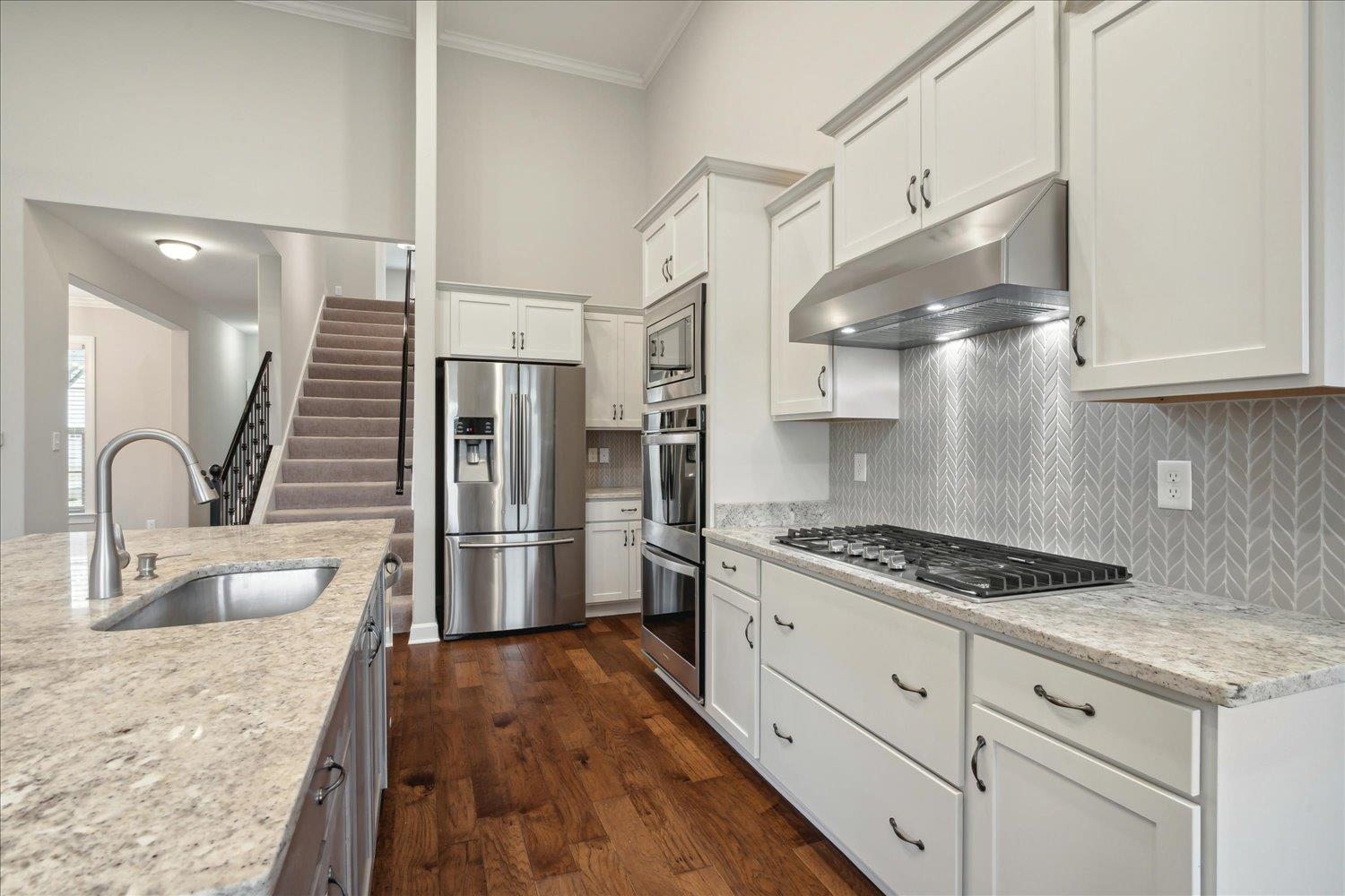 6437 Rutherford Circle Arlington, TN 38002 - Photo 8 of 40 Kitchen with ornamental molding, sink, dark wood-type flooring, appliances with stainless steel finishes, and white cabinets