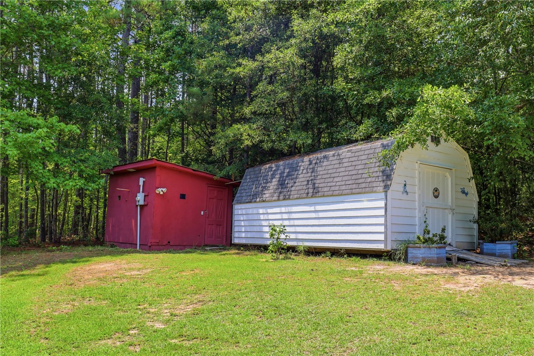 941 Scotland Road Easley, SC 29640 - Photo 19 of 25 Two charming outbuildings nestled among mature trees offer versatile storage solutions.