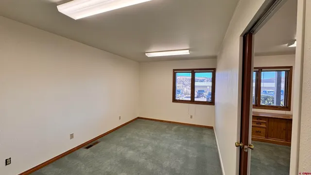 an empty room with windows and closet
