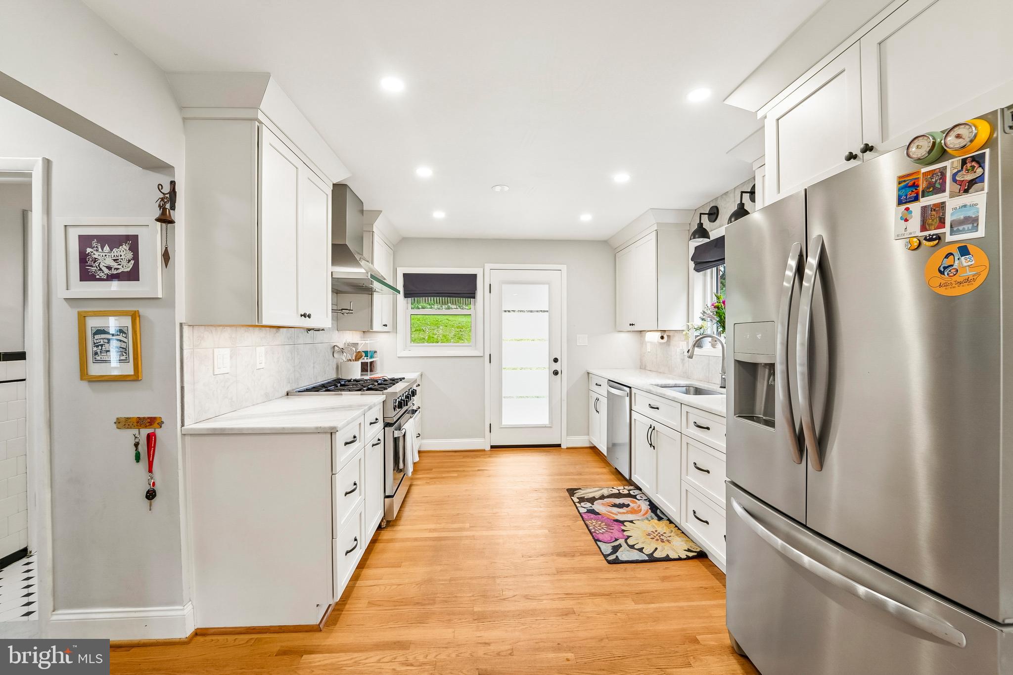 6640 Loch Hill Road Baltimore, MD 21239 - Photo 12 of 35 a kitchen with stainless steel appliances a refrigerator sink and white cabinets