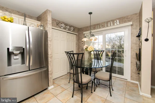 a kitchen with stainless steel appliances a refrigerator a microwave and dining table