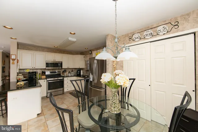 a dining room with stainless steel appliances kitchen island granite countertop a table and chairs