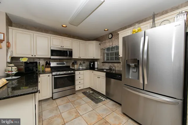 a kitchen with stainless steel appliances a refrigerator sink and microwave
