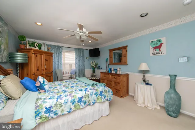 a bedroom with a bed and dresser with mirror