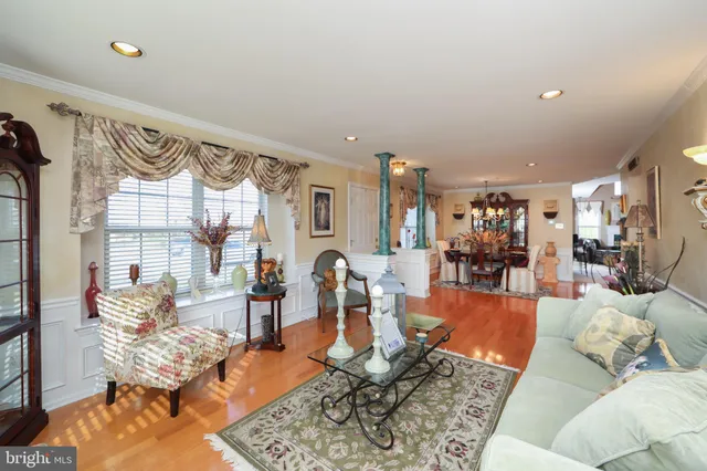 a living room with furniture wooden floor and a large window