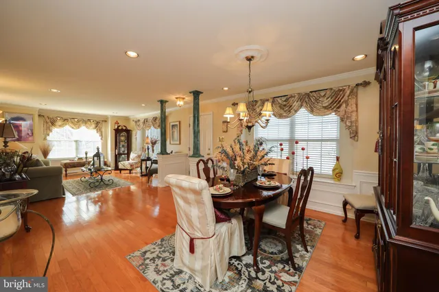 a view of a dining room and livingroom with furniture wooden floor a chandelier