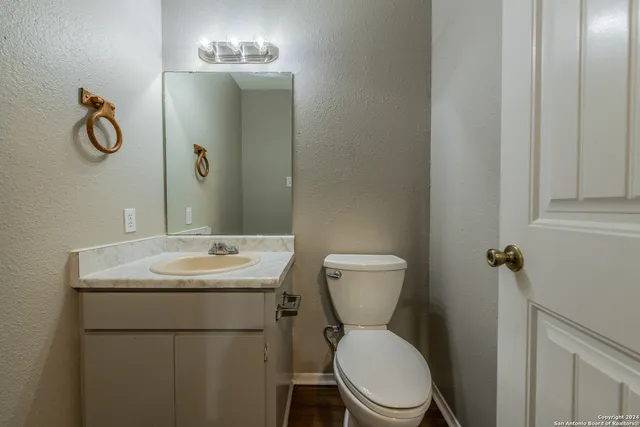 a bathroom with a toilet sink and mirror