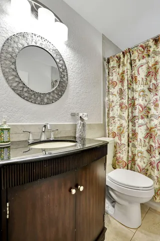 a bathroom with a sink a toilet and a mirror