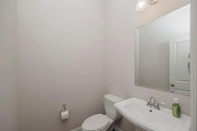 a bathroom with a sink mirror and toilet