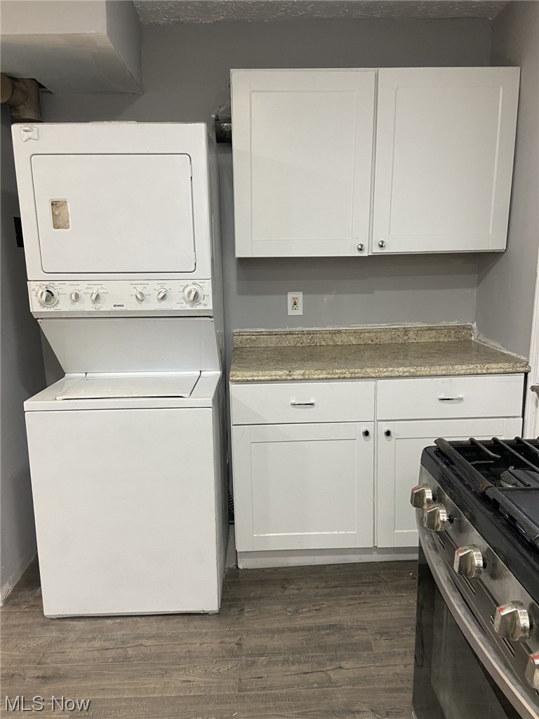 18500 Homeway Road Cleveland, OH 44135 - Photo 10 of 31 Washroom featuring dark wood-type flooring and stacked washer / dryer
