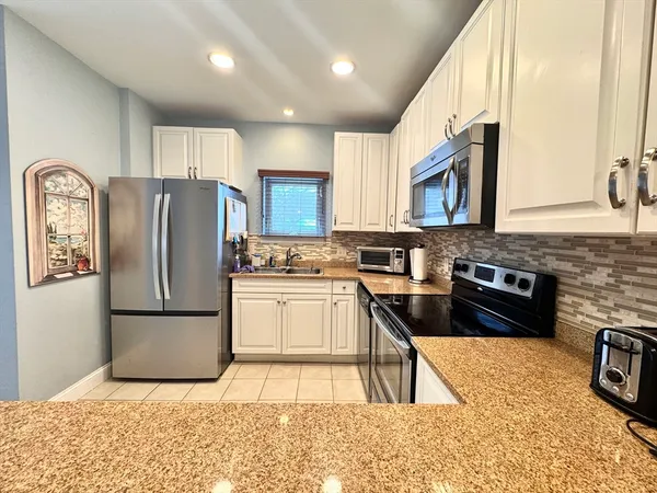 a kitchen with a refrigerator sink and cabinets