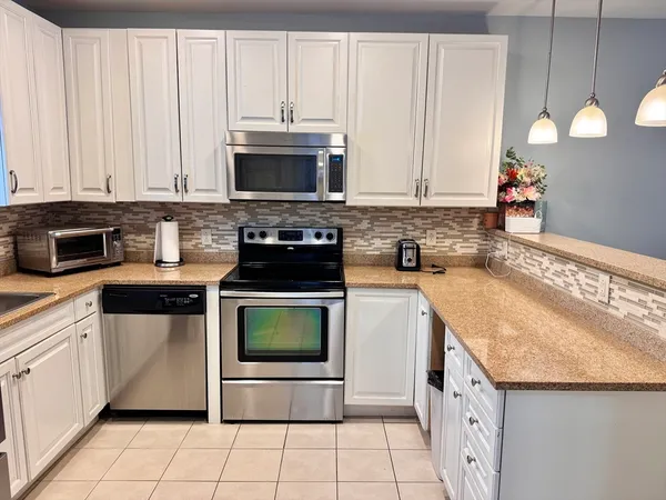 a kitchen with stainless steel appliances granite countertop a sink and a stove