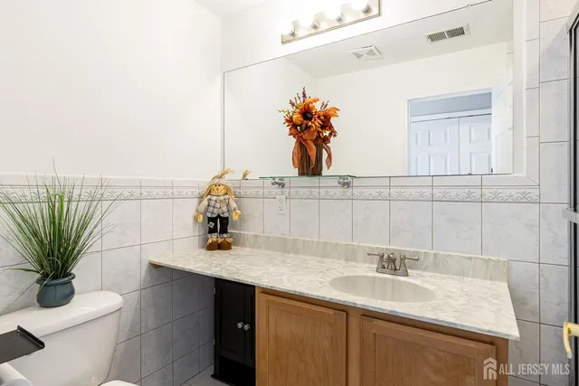 a bathroom with a sink a toilet and mirror