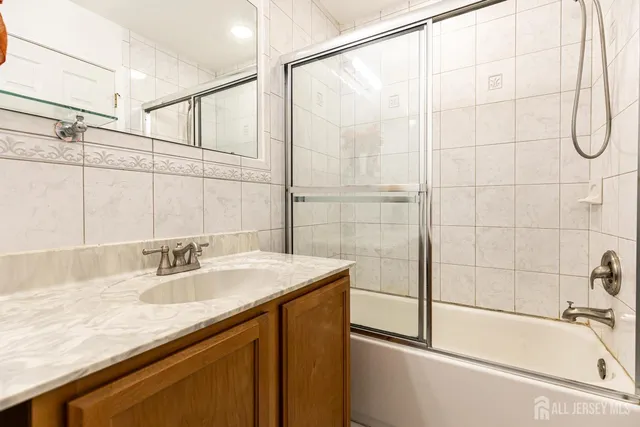 a bathroom with a granite countertop sink and a bathtub
