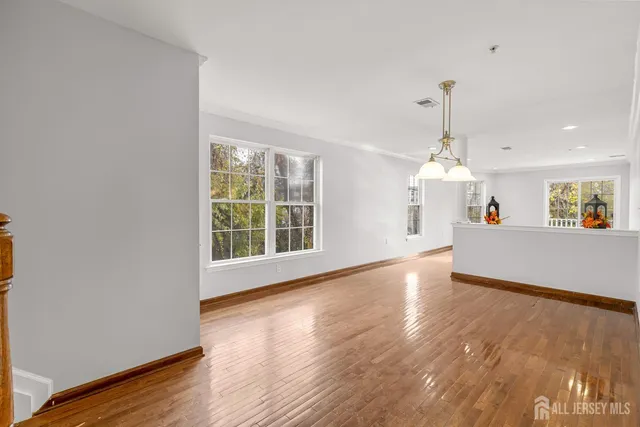 a view of a kitchen with wooden floor and a window
