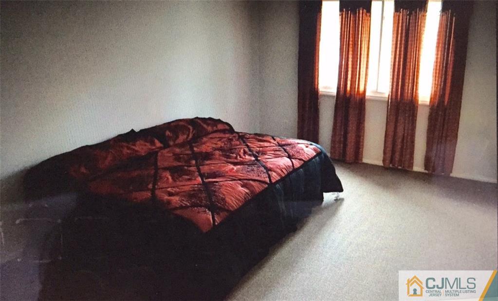 71 College Drive Edison, NJ 08817 - Photo 5 of 12 a bed sitting in a bedroom next to a window