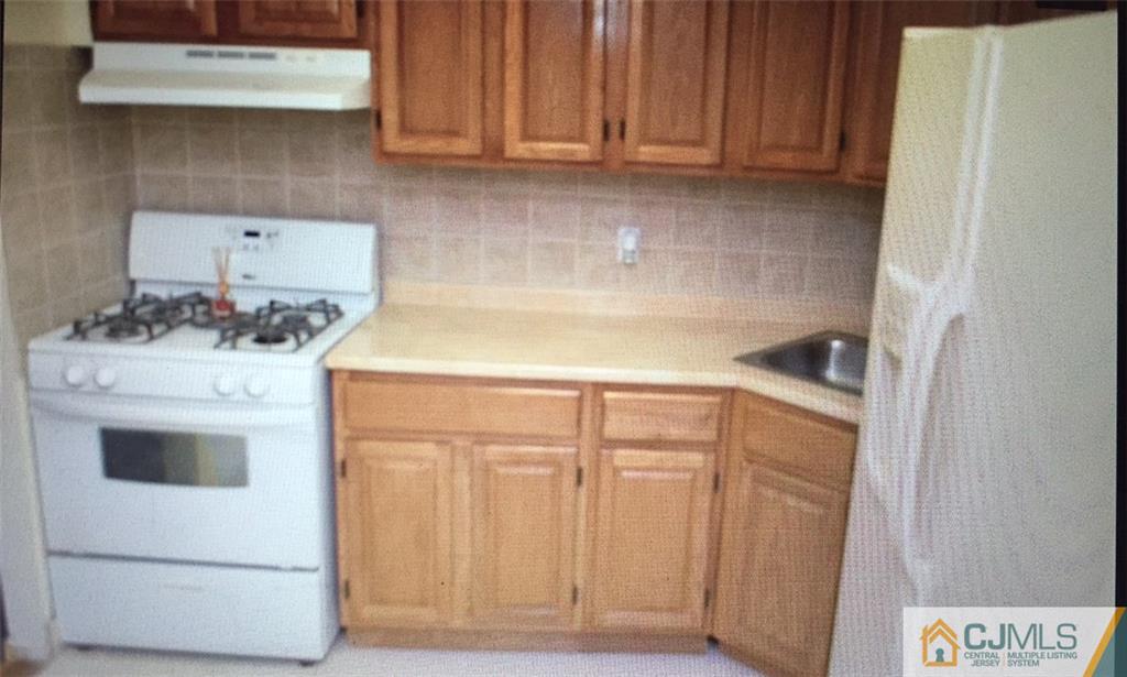 71 College Drive Edison, NJ 08817 - Photo 6 of 12 a kitchen with a stove and a refrigerator
