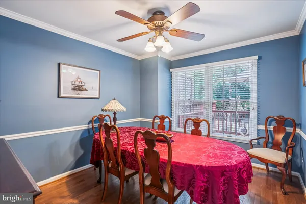 a kitchen with stainless steel appliances granite countertop a refrigerator a sink dishwasher a stove and a dining table with wooden floor