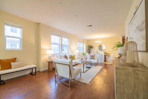 a kitchen with stainless steel appliances granite countertop a stove a refrigerator a sink a dining table and chairs