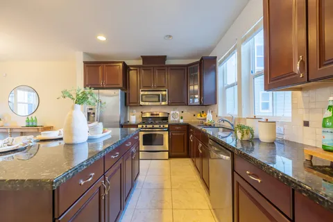 a dining room with wooden floor a chandelier a wooden table and chairs