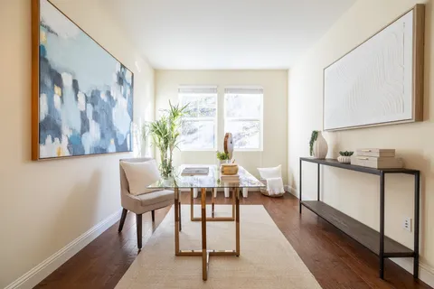 a living room with furniture a window and wooden floor