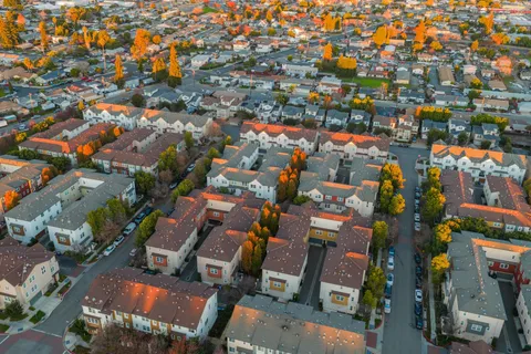 an aerial view of residential houses with outdoor space and lake view