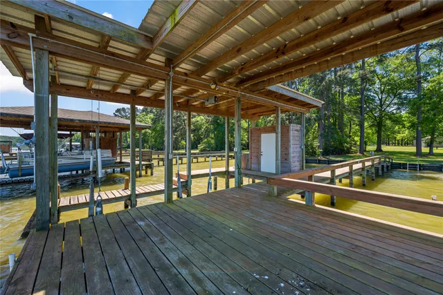 a view of a house with a big yard and potted plants and large trees