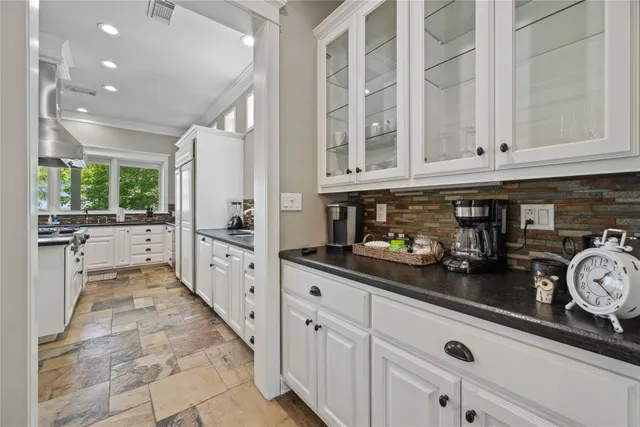 a bedroom with a large bed a chandelier and windows