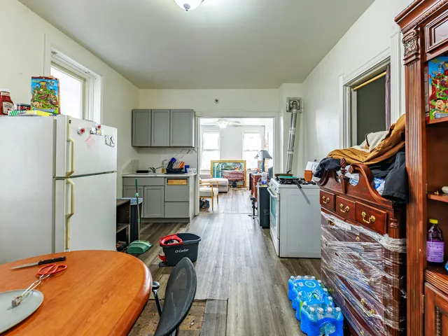a kitchen view with furniture a refrigerator and a dining table