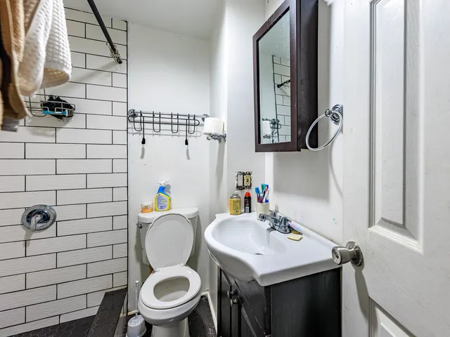 a bathroom with a sink a toilet and mirror