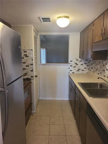 a kitchen with granite countertop a refrigerator and a sink