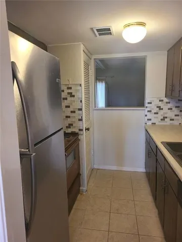 a kitchen with granite countertop a refrigerator and a sink