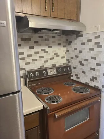 a stove top oven sitting inside of a kitchen