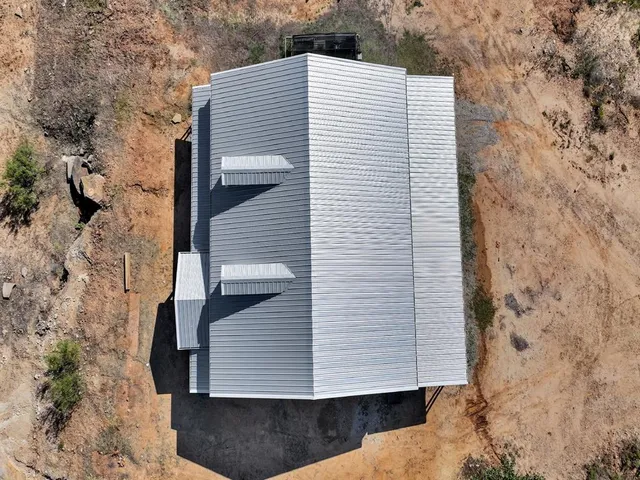 an aerial view of a house with a forest