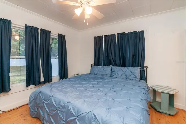 a bed sitting in a bedroom next to a window and a chandelier