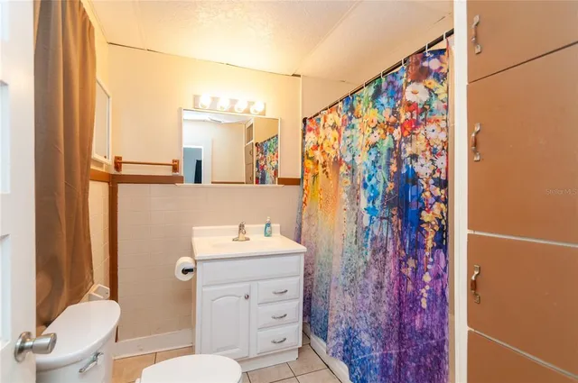 a bathroom with a toilet sink and shower curtain