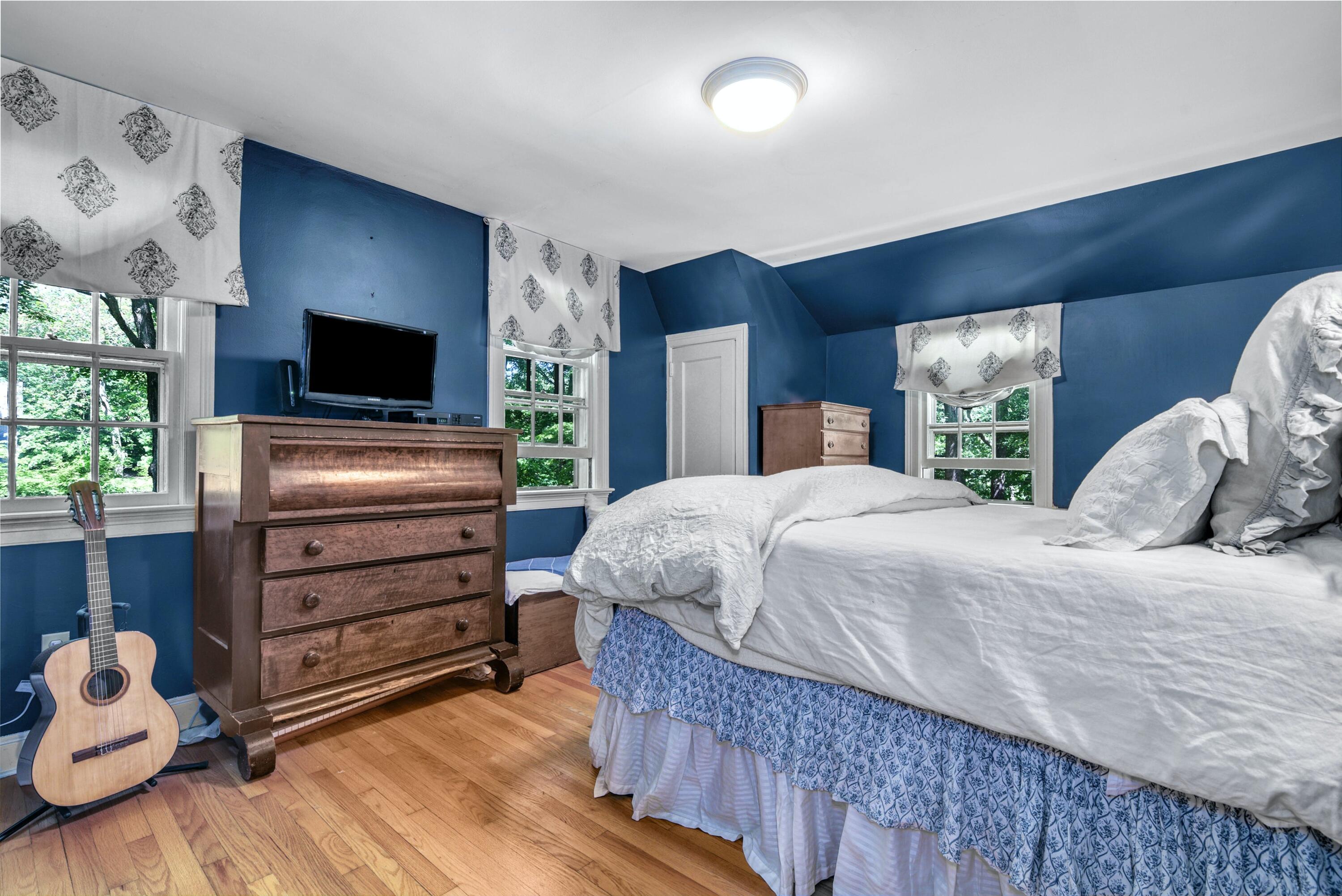 93 Westport Road Wilton, CT 06897 - Photo 14 of 31 a bedroom with a bed and a flat tv screen on dresser