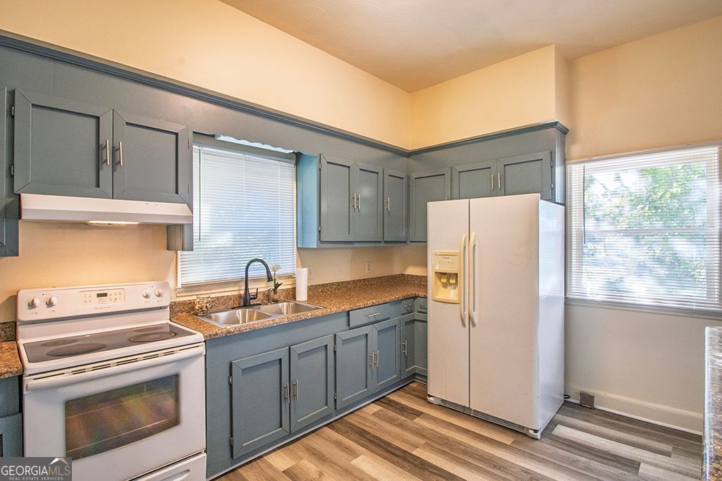 65 East Calhoun Street Wadley, GA 30477 - Photo 7 of 25 a kitchen with a white cabinets and white appliances