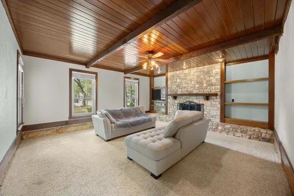 a living room with furniture a ceiling fan and a large window