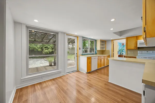 a kitchen with stainless steel appliances wooden floor and a large window