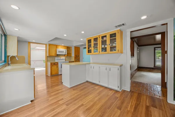 a view of a kitchen with wooden floor and a sink