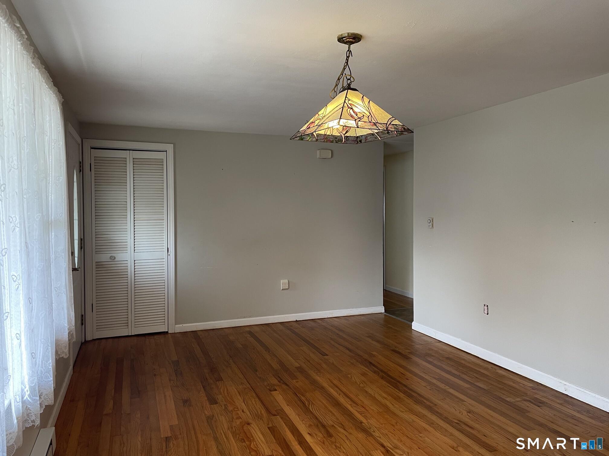18 Old South Cove Road Old Saybrook, CT 06475 - Photo 11 of 40 an empty room with wooden floor and a chandelier