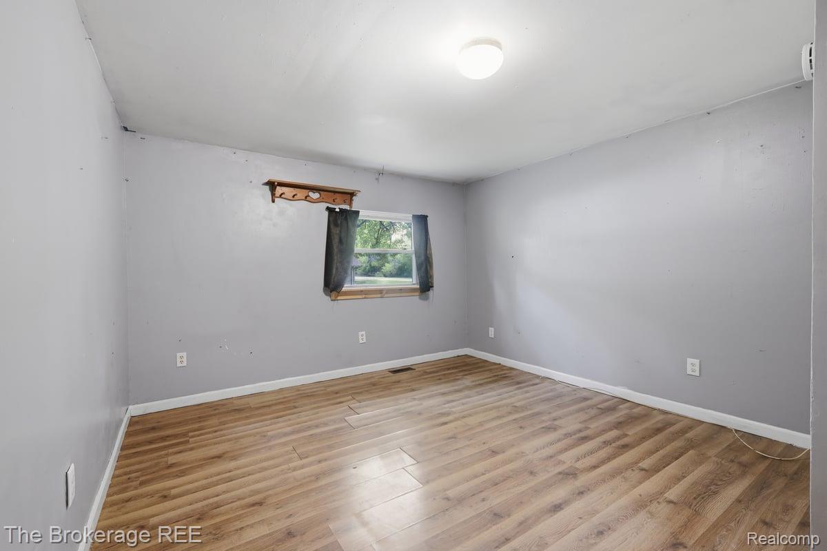 10135 Clark Road Davison, MI 48423 - Photo 28 of 38 Wood-finish flooring with light gray walls, a single window, and a ceiling-mounted light fixture