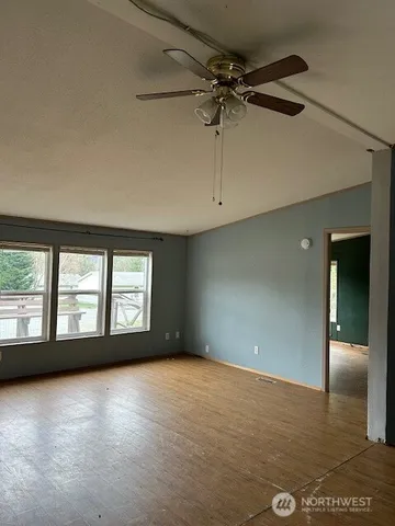 an empty room with wooden floor and a window