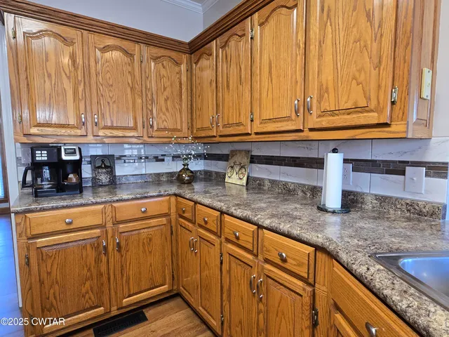 a kitchen with granite countertop a sink and cabinets