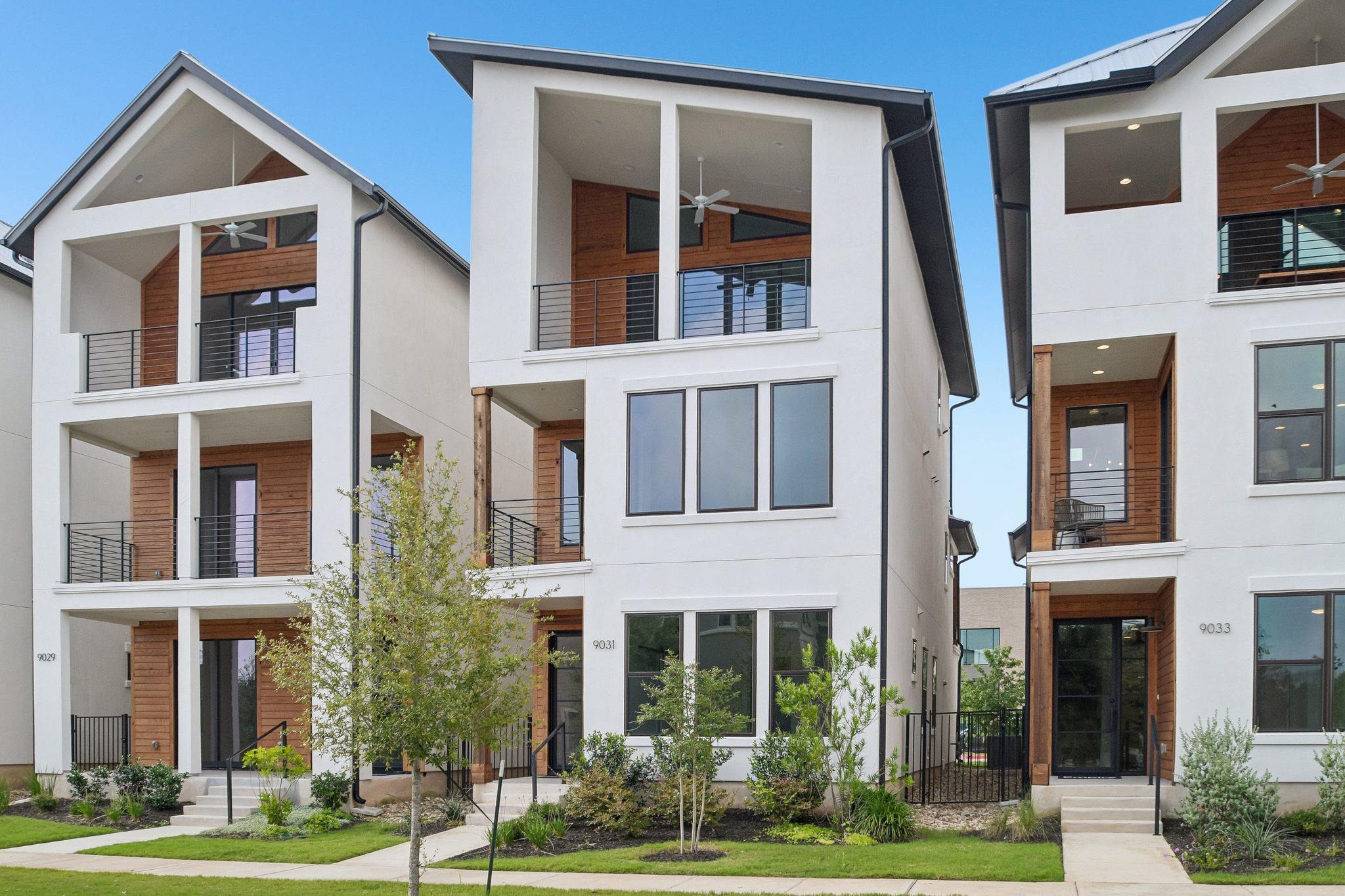 9031 Cattle Baron Path Austin, TX 78747 - Photo 3 of 31 Modern townhomes showcasing multi-story balconies and striking architectural lines.