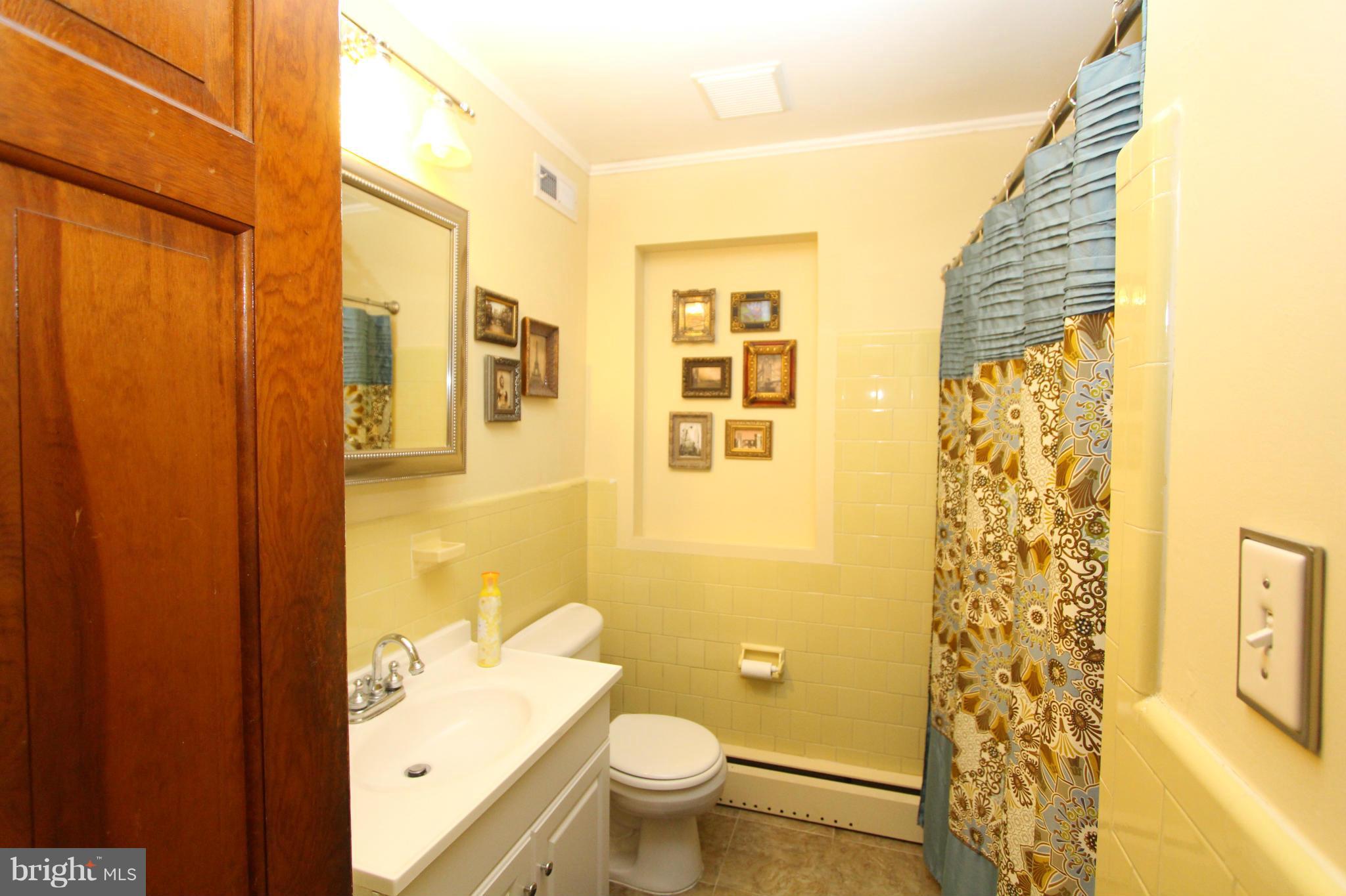 8720 Windsor Mill Road Baltimore, MD 21244 - Photo 25 of 27 a bathroom with a shower curtain a sink and a toilet